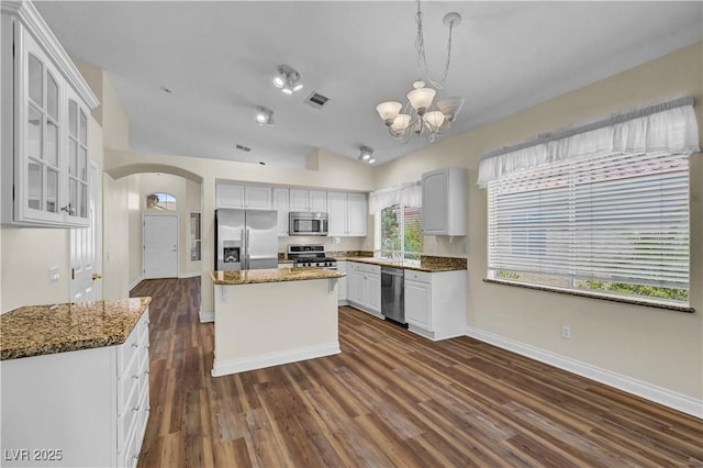 3520 Round Valley Way, Las Vegas, NV 89129 - kitchen with appliances with stainless steel finishes, arched walkways, a chandelier, dark wood-style floors, and glass insert cabinets