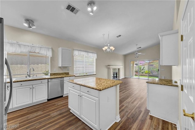 3520 Round Valley Way, Las Vegas, NV 89129 - kitchen featuring white cabinets, a fireplace, dark wood-type flooring, appliances with stainless steel finishes, and vaulted ceiling