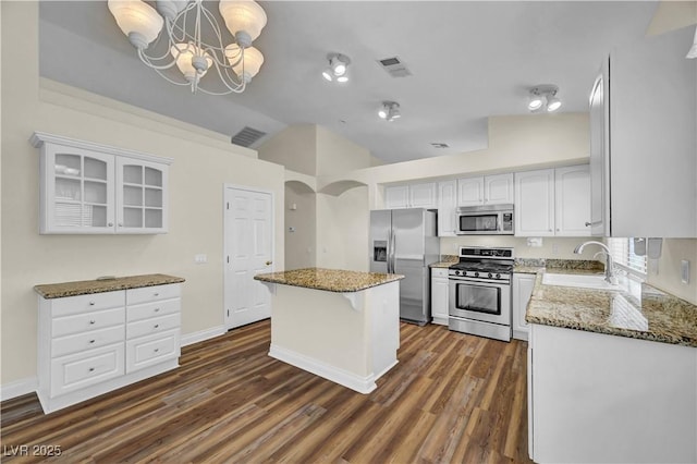 3520 Round Valley Way, Las Vegas, NV 89129 - kitchen with vaulted ceiling, appliances with stainless steel finishes, stone countertops, a kitchen island, and white cabinets