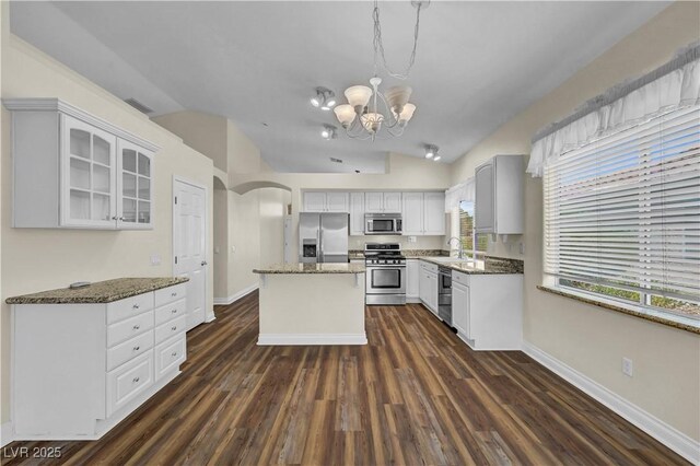 3520 Round Valley Way, Las Vegas, NV 89129 - kitchen with vaulted ceiling, a chandelier, glass insert cabinets, dark wood-style floors, and stone countertops