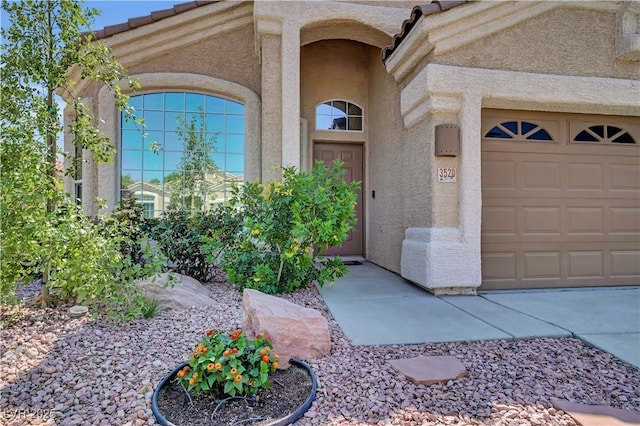 3520 Round Valley Way, Las Vegas, NV 89129 - doorway to property with stucco siding, an attached garage, and a tile roof
