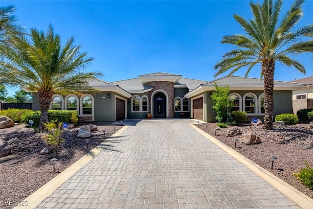 8465 Picket Ridge Ct, Las Vegas, NV 89143 - mediterranean / spanish home featuring an attached garage, decorative driveway, and stucco siding