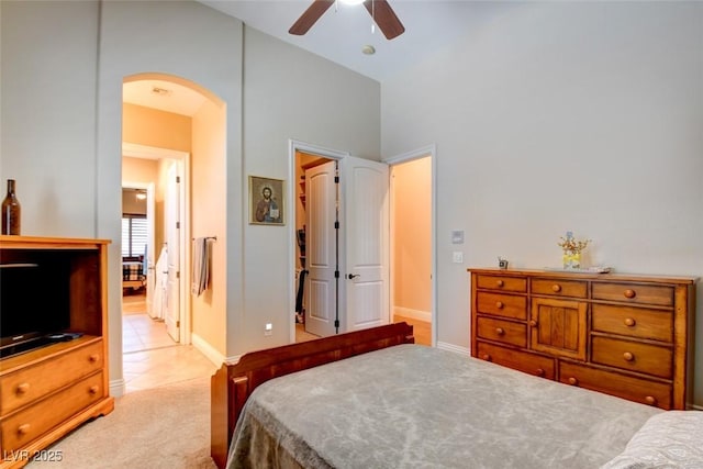 8465 Picket Ridge Ct, Las Vegas, NV 89143 - bedroom with arched walkways, light carpet, light tile patterned floors, and ceiling fan