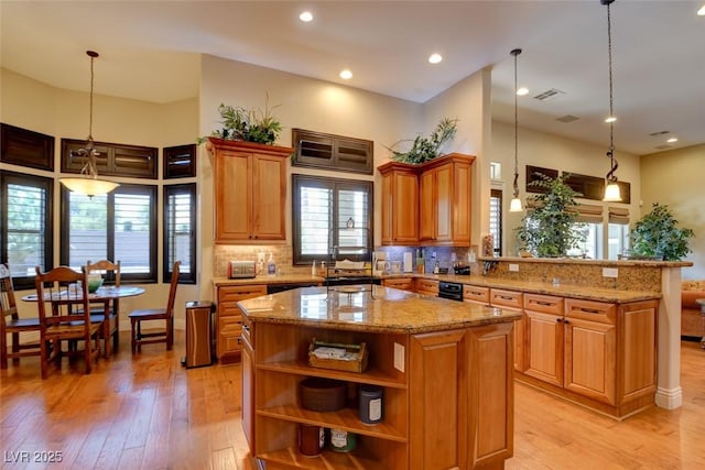 8465 Picket Ridge Ct, Las Vegas, NV 89143 - kitchen featuring light stone countertops, light wood finished floors, a center island, tasteful backsplash, and recessed lighting