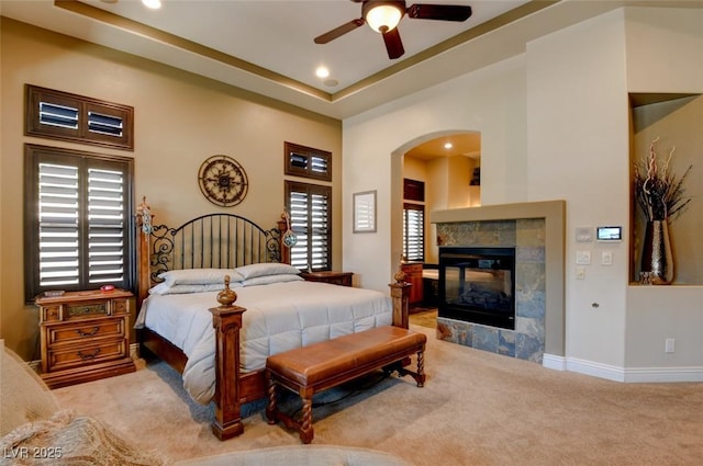 8465 Picket Ridge Ct, Las Vegas, NV 89143 - carpeted bedroom featuring arched walkways, recessed lighting, a tile fireplace, and a ceiling fan