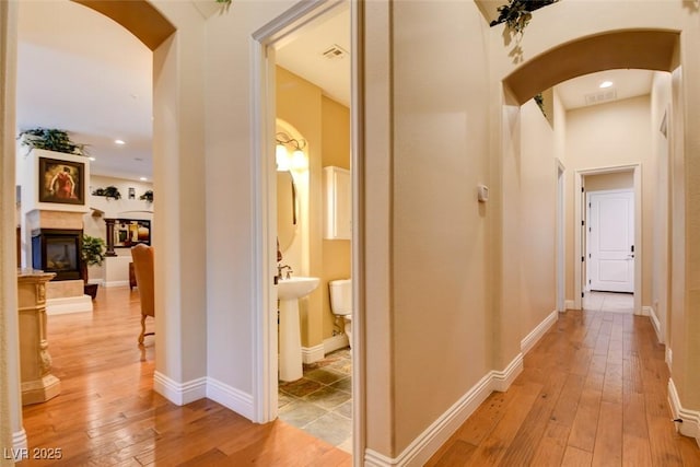 8465 Picket Ridge Ct, Las Vegas, NV 89143 - hall with arched walkways, light wood-style flooring, and recessed lighting