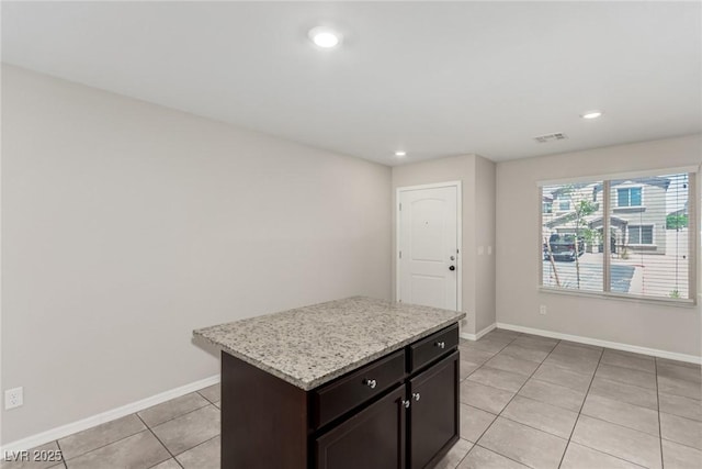 6443 Burlap Ct, Las Vegas, NV 89122 - kitchen featuring light tile patterned flooring, a kitchen island, recessed lighting, and light stone counters