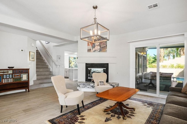 2228 Brighton Shore St, Las Vegas, NV 89128 - living area with light wood-style floors, stairway, a chandelier, and a glass covered fireplace