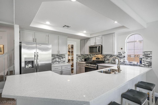 2228 Brighton Shore St, Las Vegas, NV 89128 - kitchen with stainless steel appliances, tasteful backsplash, a peninsula, light stone countertops, and recessed lighting