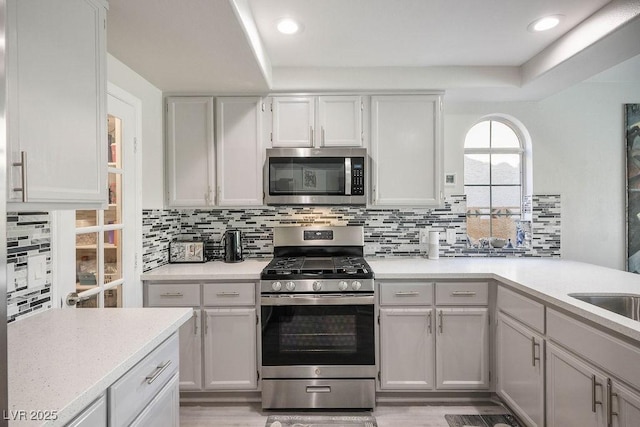 2228 Brighton Shore St, Las Vegas, NV 89128 - kitchen featuring appliances with stainless steel finishes, light countertops, decorative backsplash, a peninsula, and recessed lighting