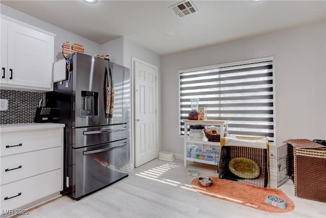 441 Groft Way, Henderson, NV 89015 - kitchen with stainless steel fridge with ice dispenser, white cabinets, decorative backsplash, light wood-style floors, and light countertops