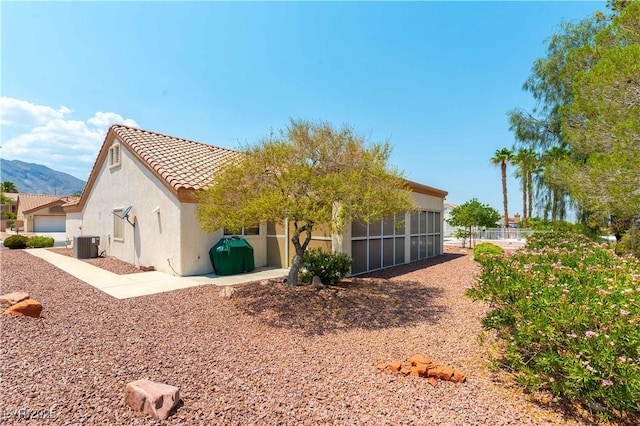 3016 Lotus Hill Dr, Las Vegas, NV 89134 - rear view of property with a sunroom, stucco siding, a tile roof, and a mountain view