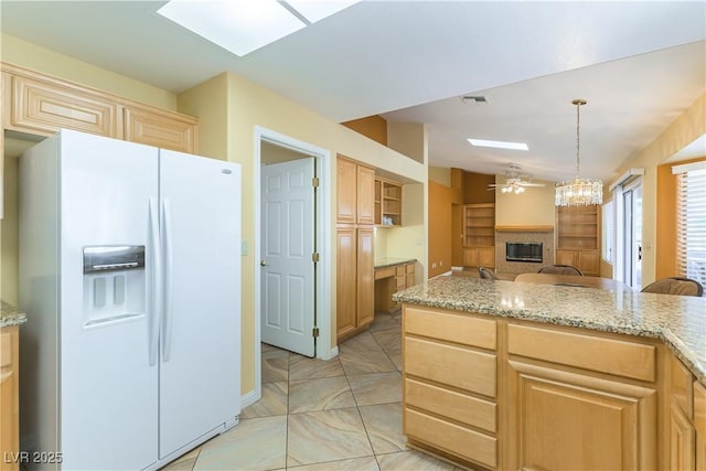 3016 Lotus Hill Dr, Las Vegas, NV 89134 - kitchen featuring white refrigerator with ice dispenser, a glass covered fireplace, light brown cabinets, open floor plan, and ceiling fan