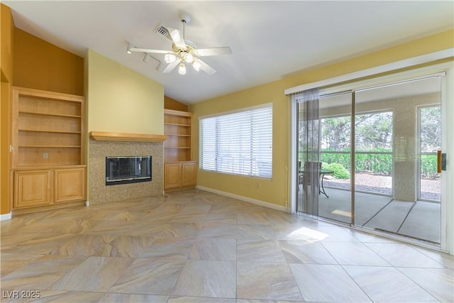 3016 Lotus Hill Dr, Las Vegas, NV 89134 - unfurnished living room with vaulted ceiling, a ceiling fan, a tile fireplace, and built in features
