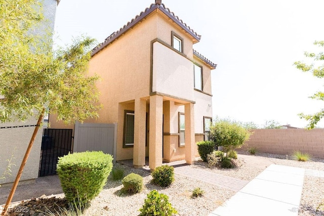 7331 Sunray Point St, North Las Vegas, NV 89084 - view of home's exterior with stucco siding, a tiled roof, and a gate