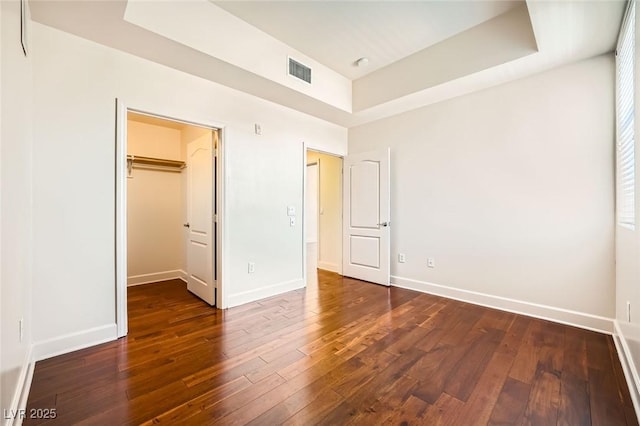 87 E Agate Ave Unit 208, Las Vegas, NV 89123 - unfurnished bedroom with dark wood-style flooring, a spacious closet, and a raised ceiling