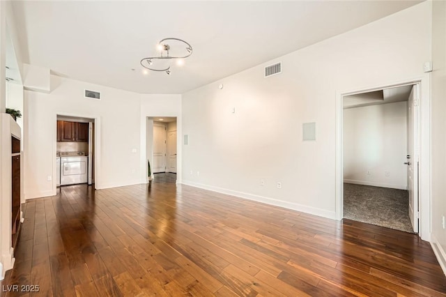 87 E Agate Ave Unit 208, Las Vegas, NV 89123 - unfurnished living room featuring dark wood-type flooring, washer / dryer, and a chandelier