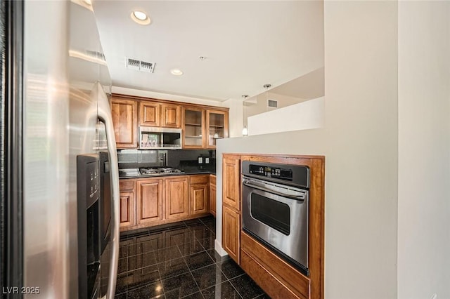 87 E Agate Ave Unit 208, Las Vegas, NV 89123 - kitchen featuring stainless steel appliances, granite tiled floors, brown cabinets, recessed lighting, and glass insert cabinets