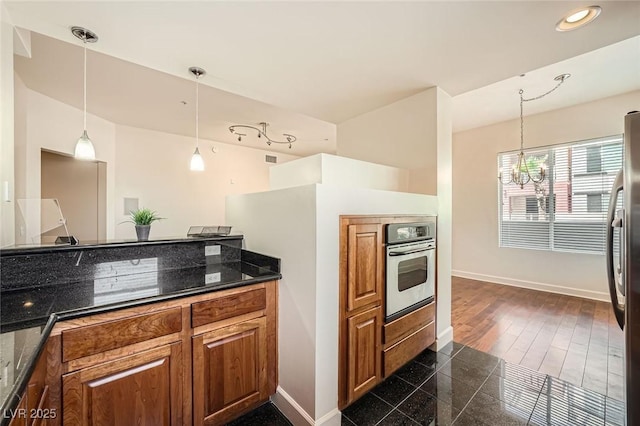 87 E Agate Ave Unit 208, Las Vegas, NV 89123 - kitchen with a chandelier, brown cabinetry, appliances with stainless steel finishes, recessed lighting, and decorative light fixtures