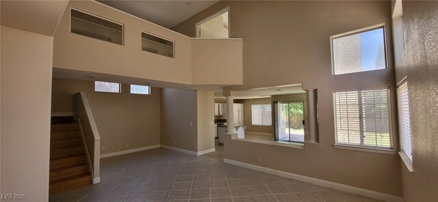 9204 Vosburgh Dr, Las Vegas, NV 89117 - unfurnished living room with a towering ceiling, stairway, and tile patterned flooring