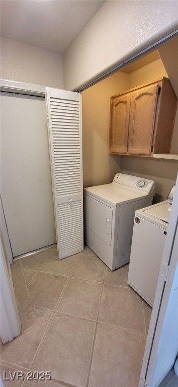 9204 Vosburgh Dr, Las Vegas, NV 89117 - washroom featuring cabinet space, washer and dryer, and light tile patterned floors
