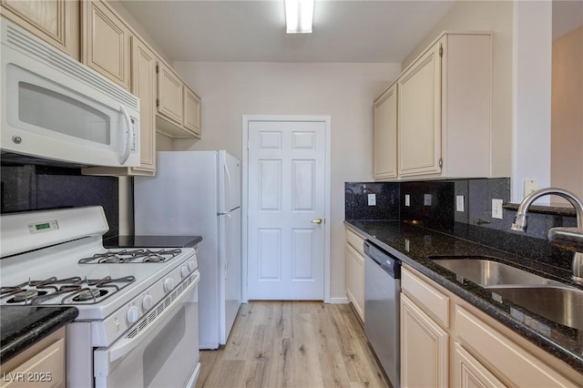 7159 S Durango Dr Unit 310, Las Vegas, NV 89113 - kitchen featuring white appliances, light wood-style flooring, dark stone counters, and decorative backsplash