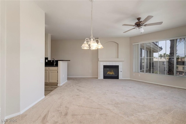 7159 S Durango Dr Unit 310, Las Vegas, NV 89113 - unfurnished living room featuring light colored carpet, a chandelier, ceiling fan, and a fireplace