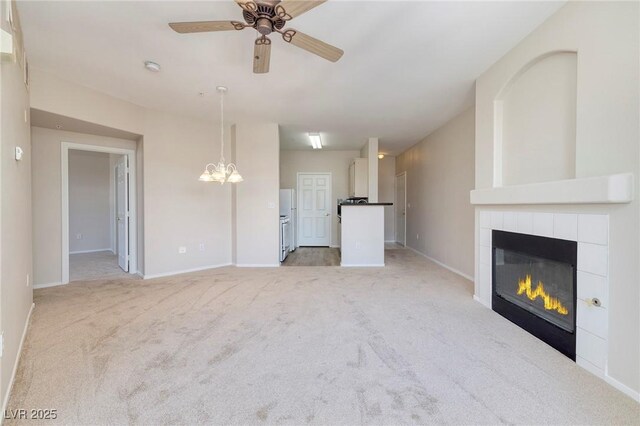 7159 S Durango Dr Unit 310, Las Vegas, NV 89113 - unfurnished living room with light colored carpet, ceiling fan, a fireplace, and a chandelier