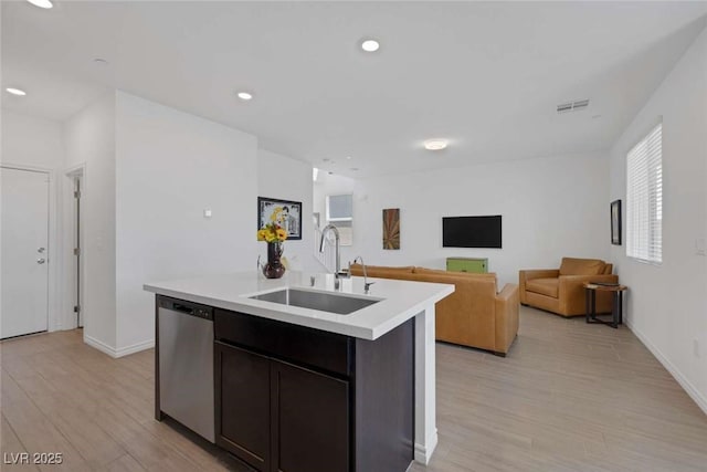 9827 Mojave Mountain St, Las Vegas, NV 89166 - kitchen with light wood-style flooring, light countertops, open floor plan, stainless steel dishwasher, and a center island with sink
