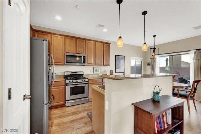 9916 Fallowdeer Ct, Las Vegas, NV 89149 - kitchen featuring appliances with stainless steel finishes, a center island, light wood-style flooring, hanging light fixtures, and recessed lighting