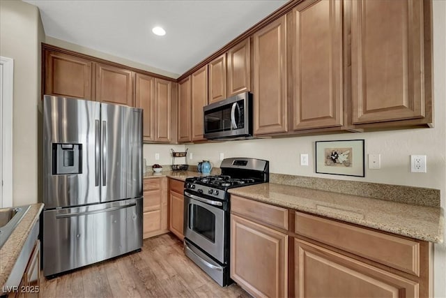 9916 Fallowdeer Ct, Las Vegas, NV 89149 - kitchen featuring stainless steel appliances, light wood-style flooring, light stone countertops, and recessed lighting