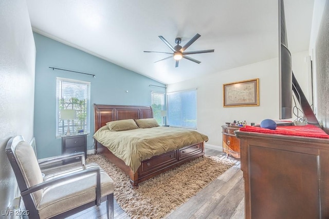 7824 Indian Cloud Ave, Las Vegas, NV 89129 - bedroom featuring vaulted ceiling, wood finished floors, multiple windows, and a ceiling fan