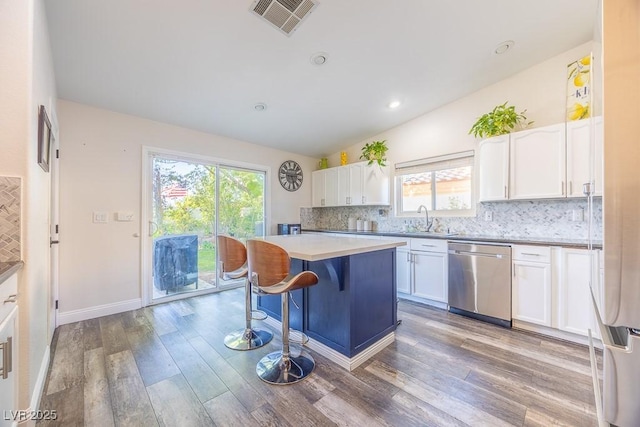7824 Indian Cloud Ave, Las Vegas, NV 89129 - kitchen featuring white cabinets, a kitchen island, backsplash, wood finished floors, and vaulted ceiling