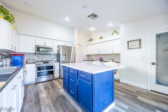 7824 Indian Cloud Ave, Las Vegas, NV 89129 - kitchen featuring blue cabinetry, dark wood finished floors, white cabinets, stainless steel appliances, and recessed lighting
