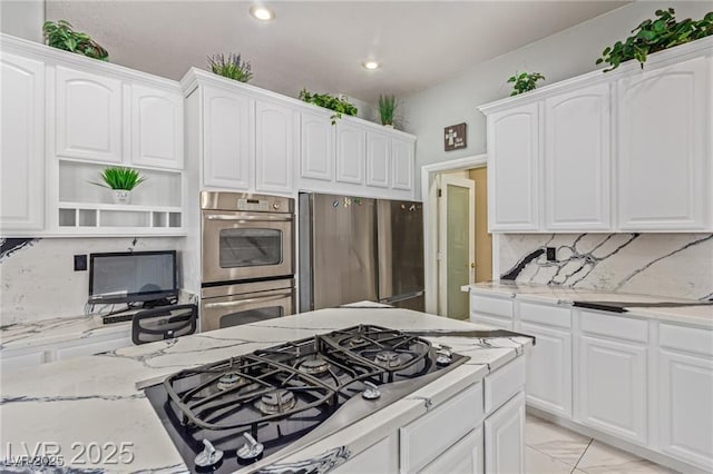 60 N Fogg St, Las Vegas, NV 89110 - kitchen with stainless steel appliances, light stone countertops, tasteful backsplash, open shelves, and white cabinetry