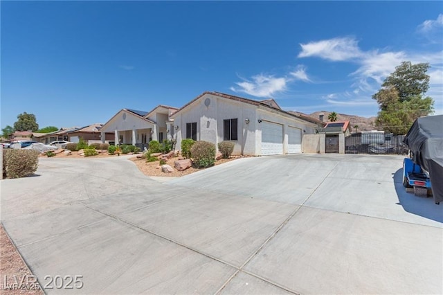 60 N Fogg St, Las Vegas, NV 89110 - view of front of house featuring concrete driveway, an attached garage, a residential view, and stucco siding