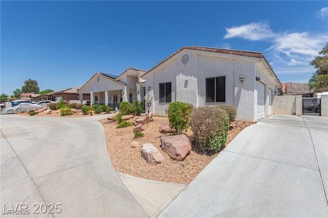 60 N Fogg St, Las Vegas, NV 89110 - view of front of property featuring concrete driveway, stucco siding, and a gate