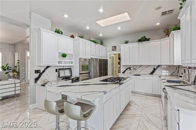 60 N Fogg St, Las Vegas, NV 89110 - kitchen with a center island, a skylight, decorative backsplash, light marble finish floors, and light stone countertops