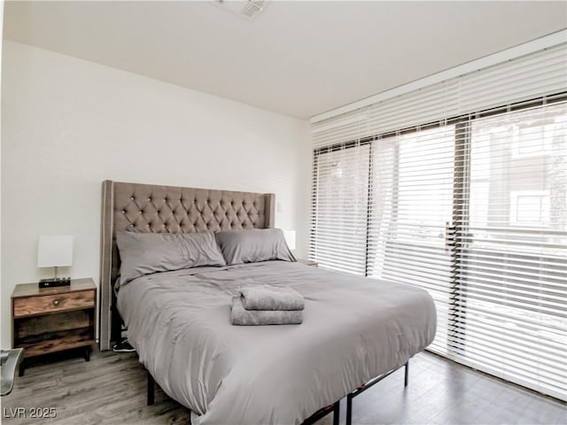 5042 S Rainbow Blvd Unit 103, Las Vegas, NV 89118 - bedroom with wood finished floors, multiple windows, and access to exterior