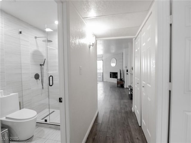 5042 S Rainbow Blvd Unit 103, Las Vegas, NV 89118 - bathroom with a stall shower, wood finished floors, and a large fireplace
