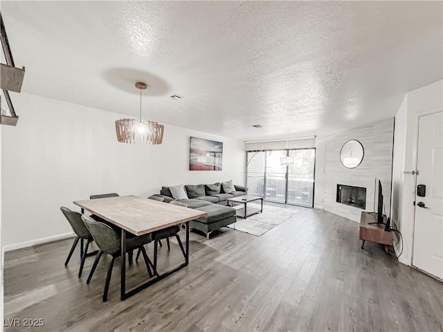 5042 S Rainbow Blvd Unit 103, Las Vegas, NV 89118 - dining area featuring a textured ceiling, wood finished floors, and a large fireplace