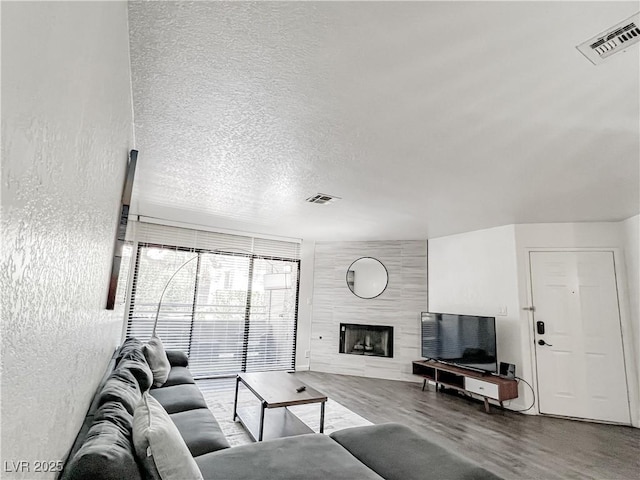 5042 S Rainbow Blvd Unit 103, Las Vegas, NV 89118 - living room with wood finished floors, a textured ceiling, and a fireplace