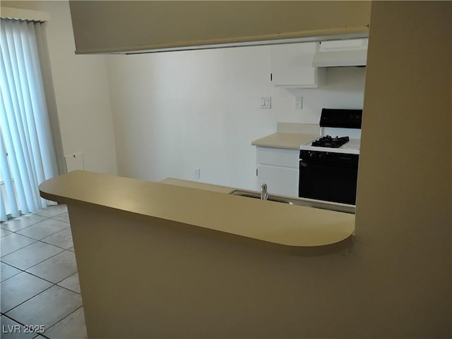425 N Lamb Blvd Unit D, Las Vegas, NV 89110 - kitchen with exhaust hood, range with gas stovetop, white cabinets, light countertops, and light tile patterned flooring