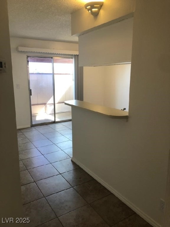 425 N Lamb Blvd Unit D, Las Vegas, NV 89110 - tiled empty room with a textured ceiling and baseboards