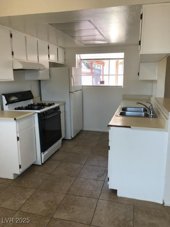 425 N Lamb Blvd Unit D, Las Vegas, NV 89110 - kitchen with white appliances, under cabinet range hood, white cabinets, light countertops, and tile patterned floors