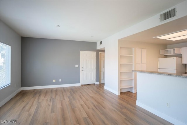 9580 W Reno Ave Unit 240, Las Vegas, NV 89148 - unfurnished living room with built in features and light wood-style floors