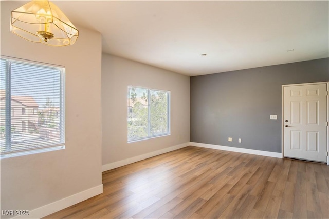 9580 W Reno Ave Unit 240, Las Vegas, NV 89148 - unfurnished room with light wood-style flooring and a chandelier