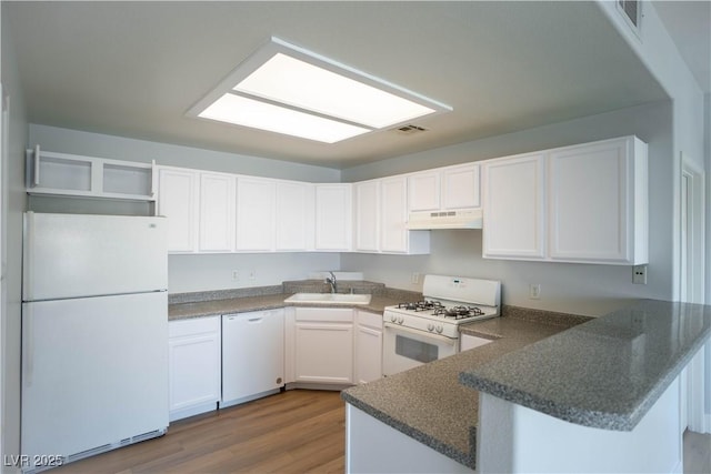 9580 W Reno Ave Unit 240, Las Vegas, NV 89148 - kitchen featuring white appliances, a peninsula, dark wood-style flooring, dark countertops, and white cabinetry