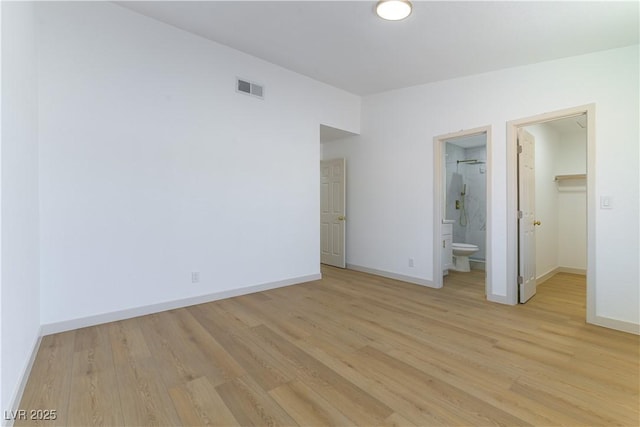 6760 Fallona Ave, Las Vegas, NV 89156 - unfurnished bedroom featuring light wood-type flooring, a walk in closet, and ensuite bath