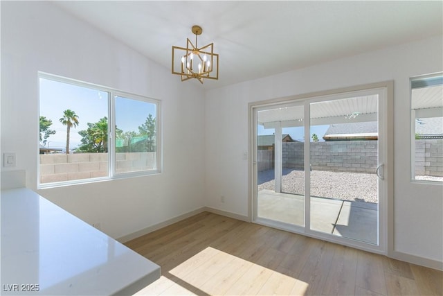 6760 Fallona Ave, Las Vegas, NV 89156 - unfurnished dining area featuring wood finished floors and a chandelier